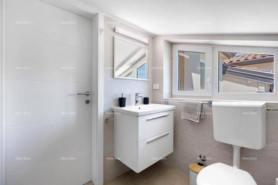 Modernes Badezimmer mit Waschbecken, Toilette und Fenster, hell gefliest.