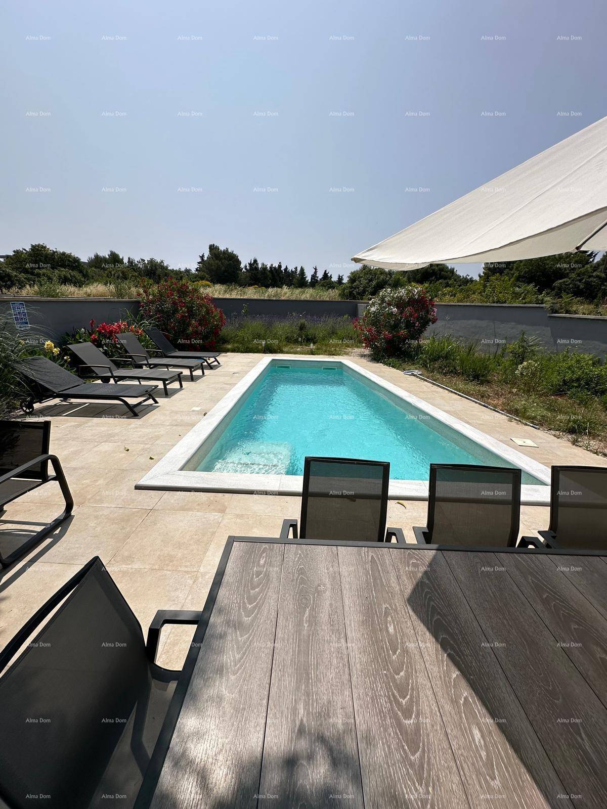 Essbereich im Freien mit Blick auf den Pool und die weite, grüne Landschaft.