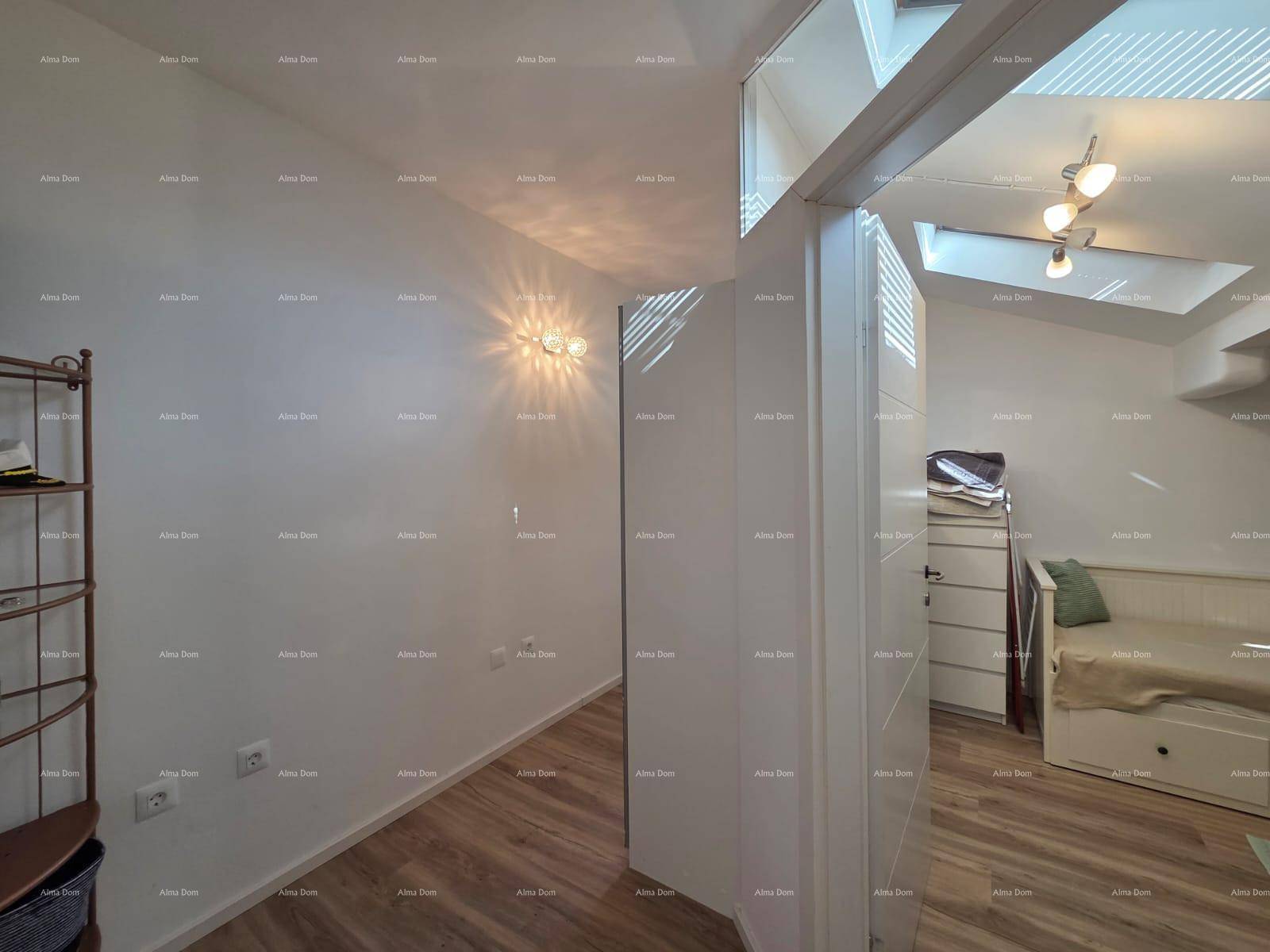 Helles Schlafzimmer mit Dachschrägen, Dachfenstern und einem einfachen Bett, funktional eingerichtet.