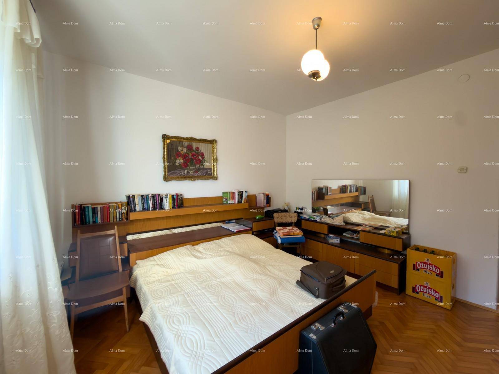Schlafzimmer mit Doppelbett, Parkettboden und einem großen Spiegel über der Kommode.