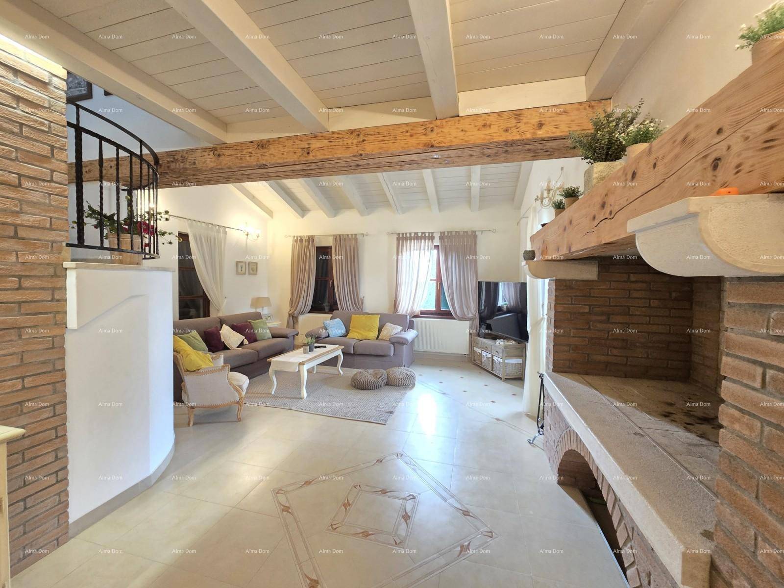 Gemütliches Wohnzimmer mit sichtbaren Holzbalken, Fliesenboden und einem großen Kaminbereich.