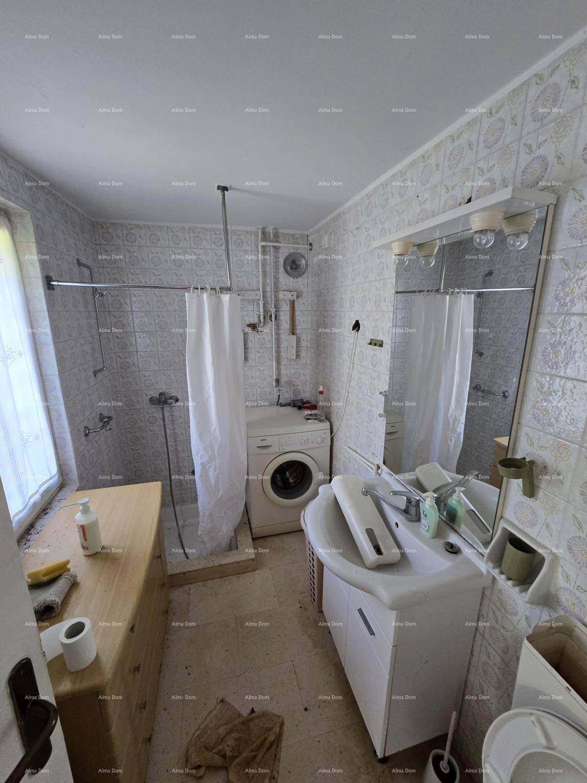 Einfaches Badezimmer mit Dusche, Waschbecken, Toilette und Waschmaschine, funktional eingerichtet.