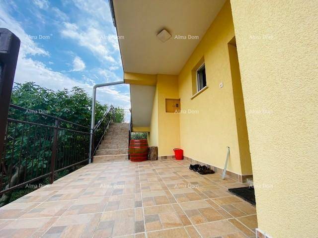 Überdachte Terrasse mit Fliesenboden und Treppe zum oberen Bereich.
