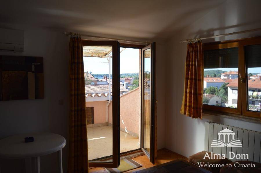 Wohnzimmer mit Balkonzugang und weitem Blick über die Dächer und das Meer.