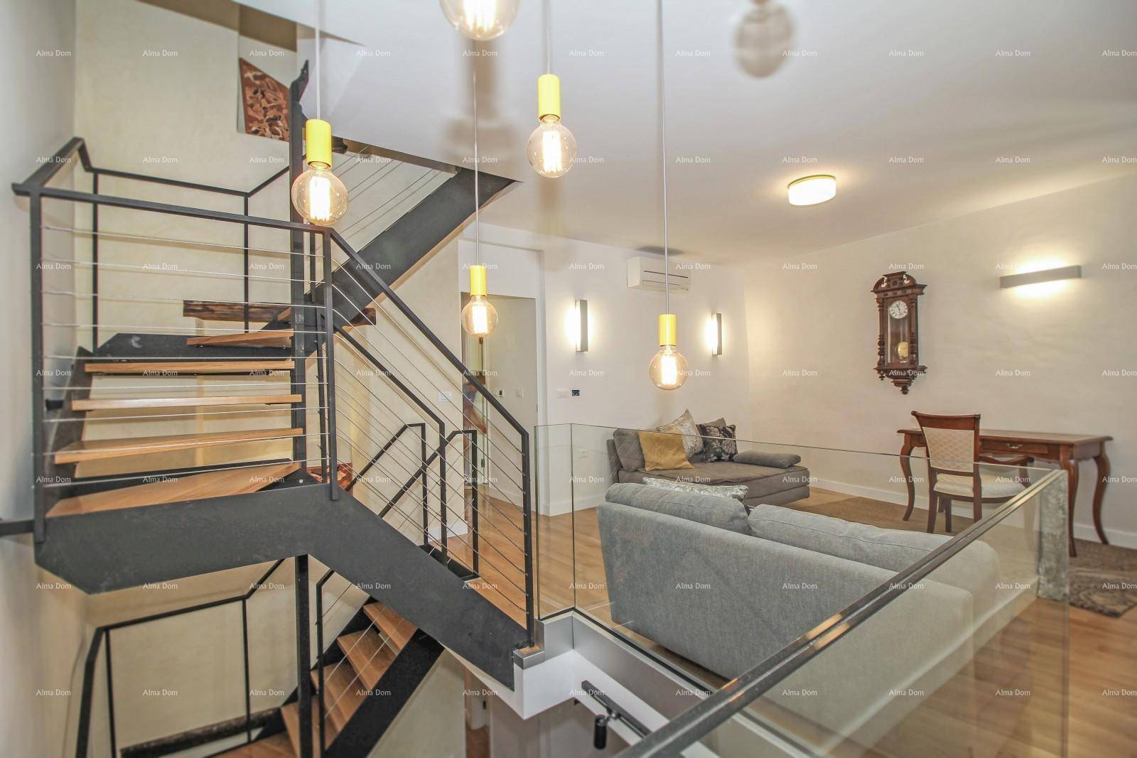 Geräumiger Wohnbereich mit offener Treppe, bequemer Couch und stilvoller Wanddekoration.