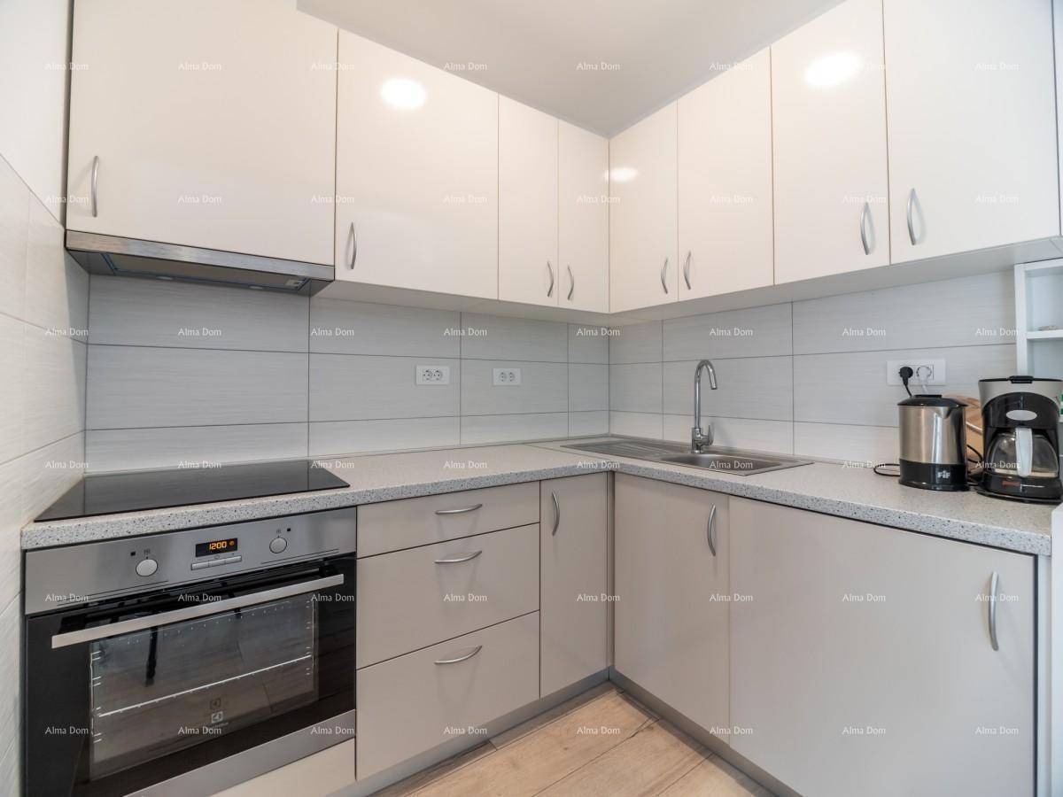 Moderne Küche mit weißen Hochglanzschränken, Einbauherd, Induktionskochfeld und gefliestem Spritzschutz.