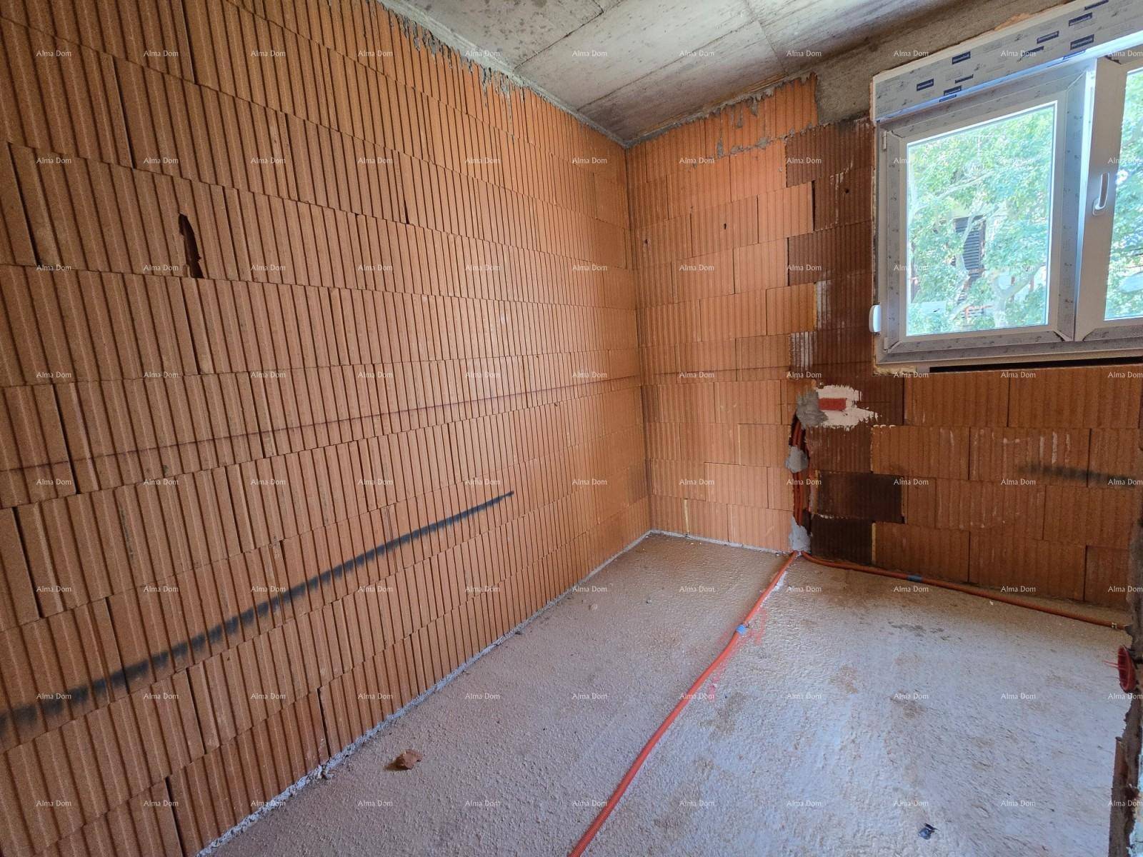 Rohbauzimmer mit unverputzten Ziegelwänden, Betonboden und einem Fenster, das Tageslicht hereinlässt.