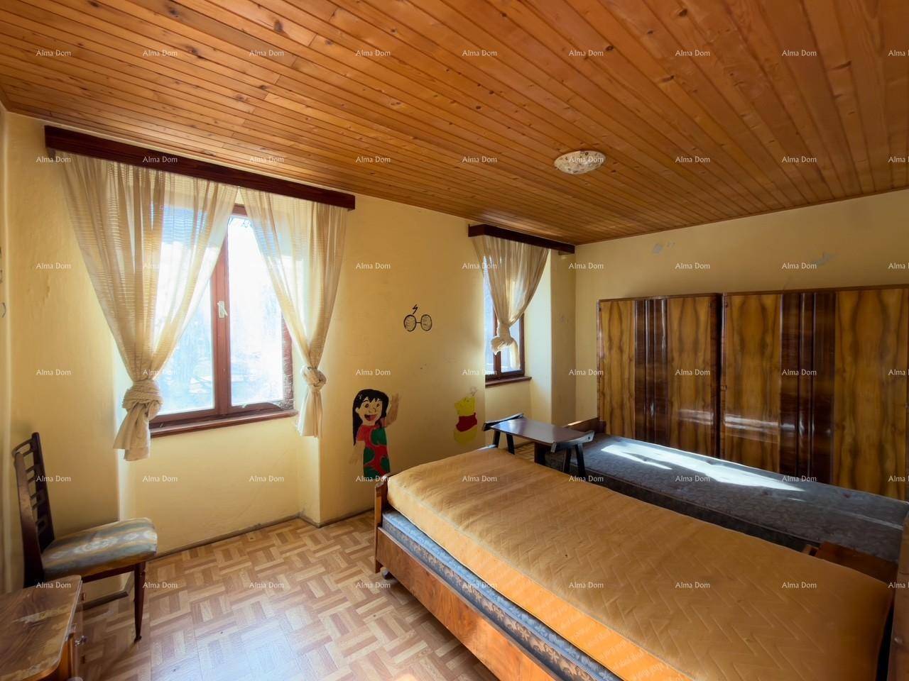 Schlafzimmer mit Holzdecke, zwei Betten und einem großen Kleiderschrank, hell durch Tageslicht.