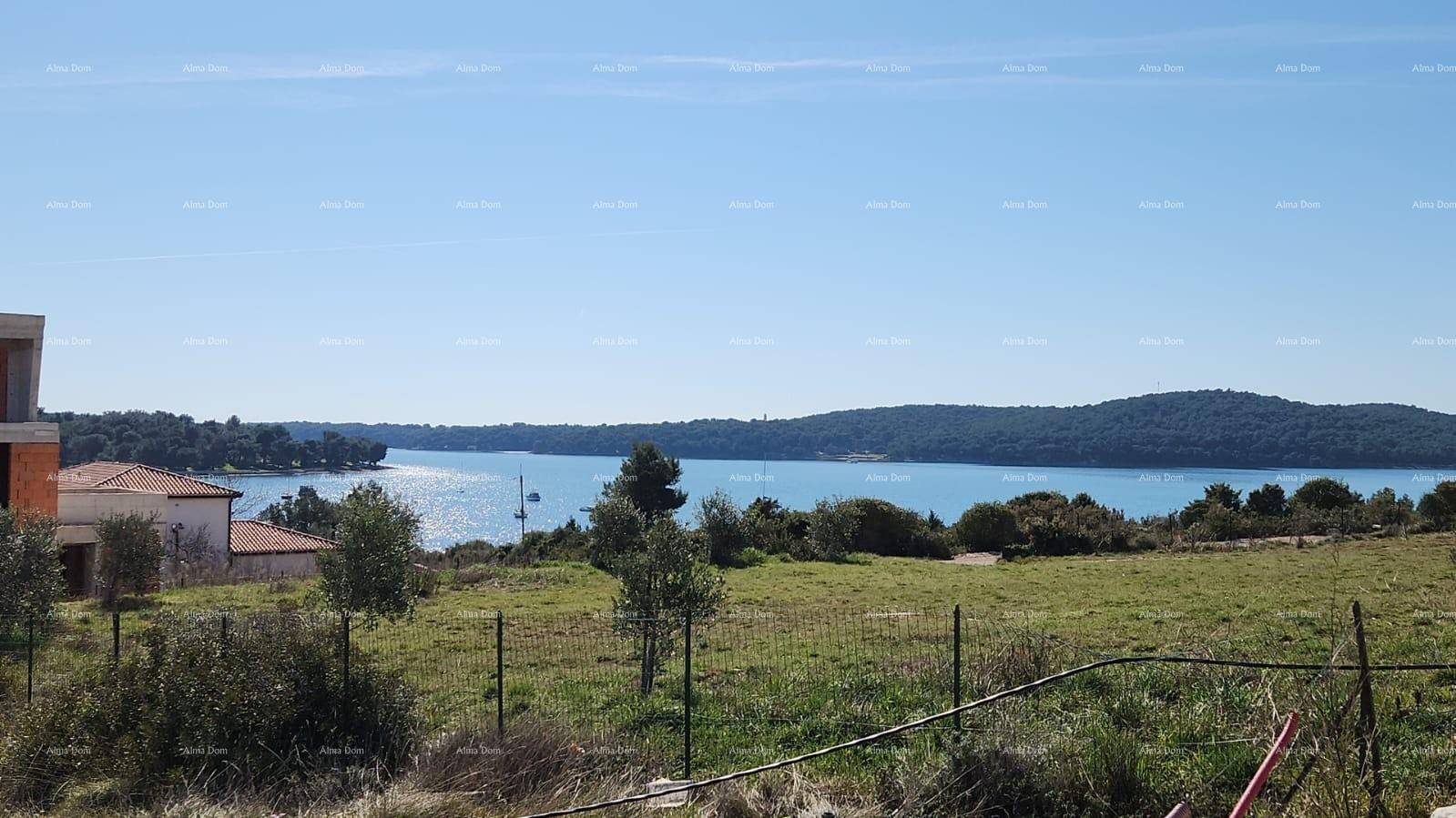 Panoramablick auf das glitzernde Meer und die umliegende Landschaft mit Neubauten.
