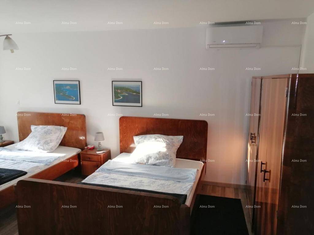 Schlafzimmer mit zwei Einzelbetten, Holzrahmen und Klimaanlage für angenehme Nächte.