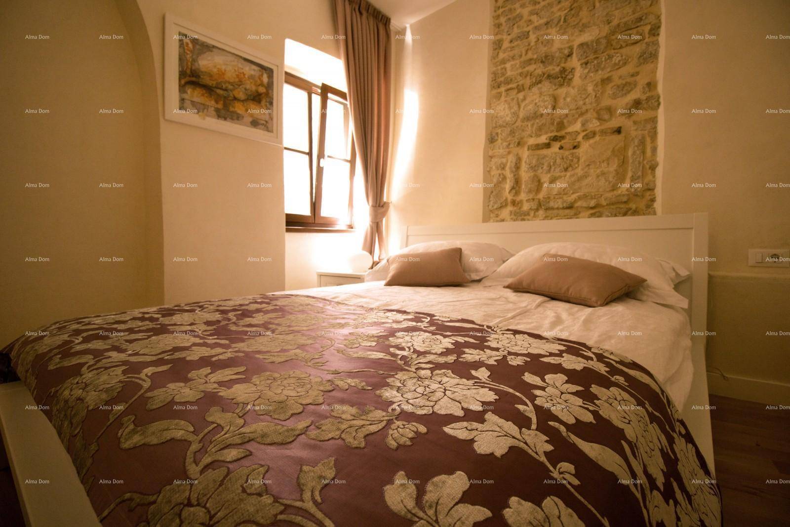 Helles Schlafzimmer mit Doppelbett, Holzboden und einer Akzentwand aus Naturstein.