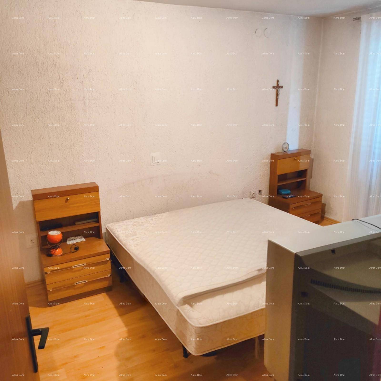 Schlichtes Schlafzimmer mit hellem Holzboden, weißen Wänden und zwei einfachen Nachttischen.
