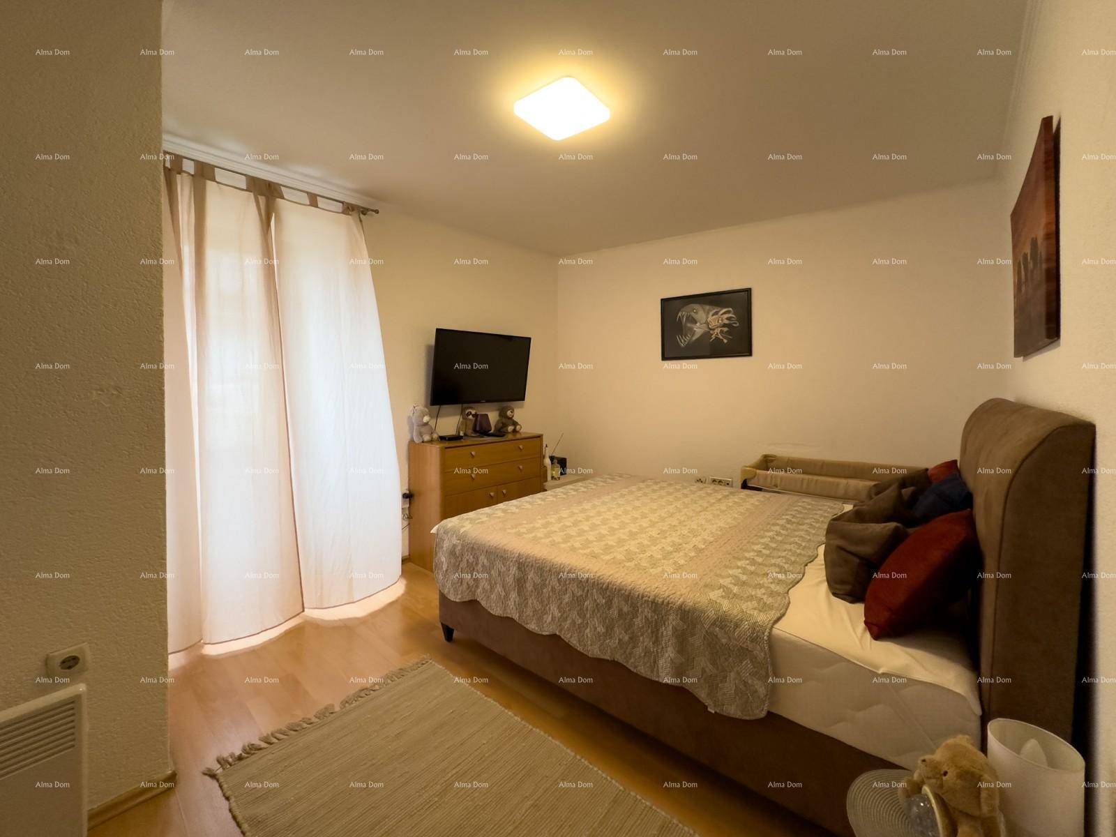 Schlafzimmer mit Doppelbett, Holzfußboden und Vorhängen für Privatsphäre.