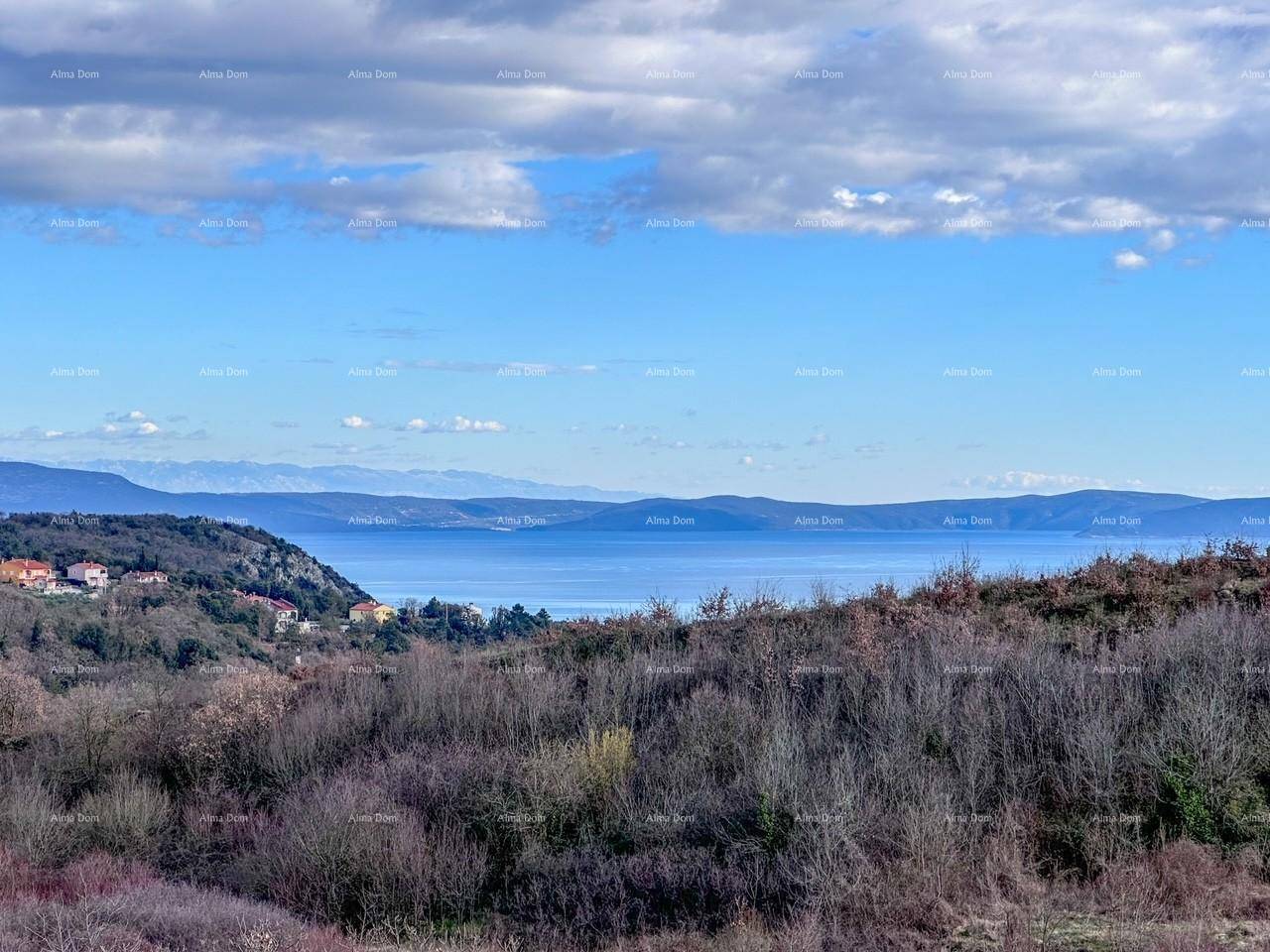 Panoramablick auf das weite Meer und die umliegende Hügellandschaft unter blauem Himmel.