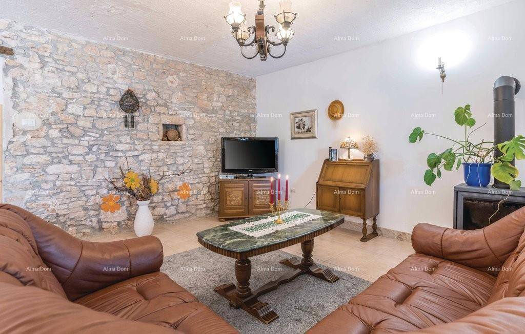 Gemütliches Wohnzimmer mit Steinwand, Ledersofas und traditionellem Holzofen.