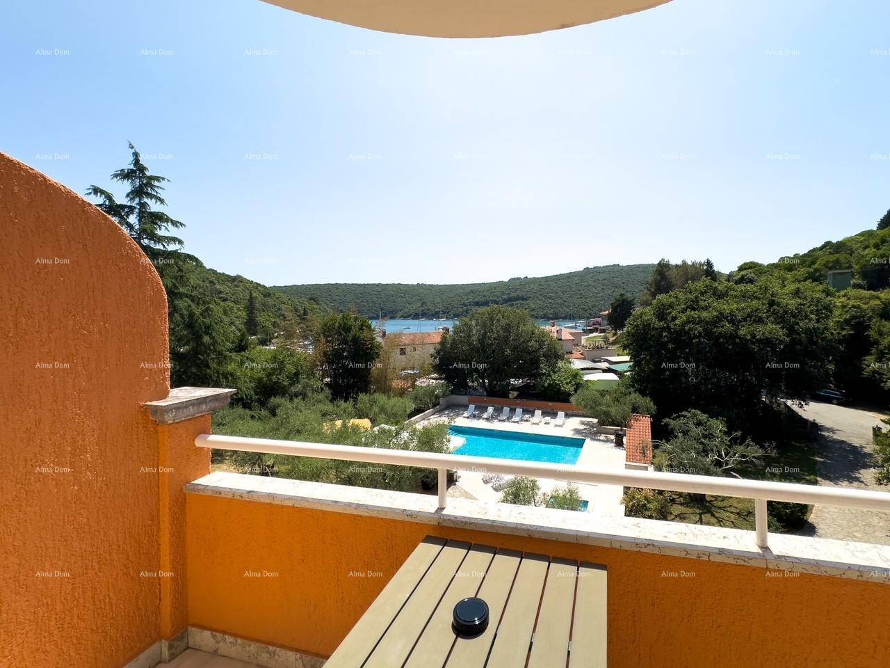 Balkon mit weitem Blick über den Pool, die grüne Landschaft und die Bucht mit dem Meer.