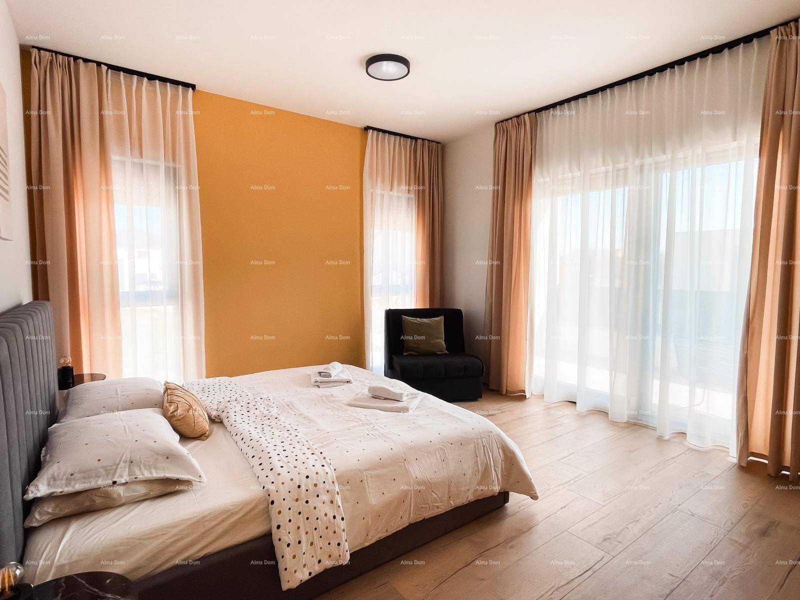 Geräumiges Schlafzimmer mit Holzboden, großen Fenstern und Zugang zu einem Balkon.