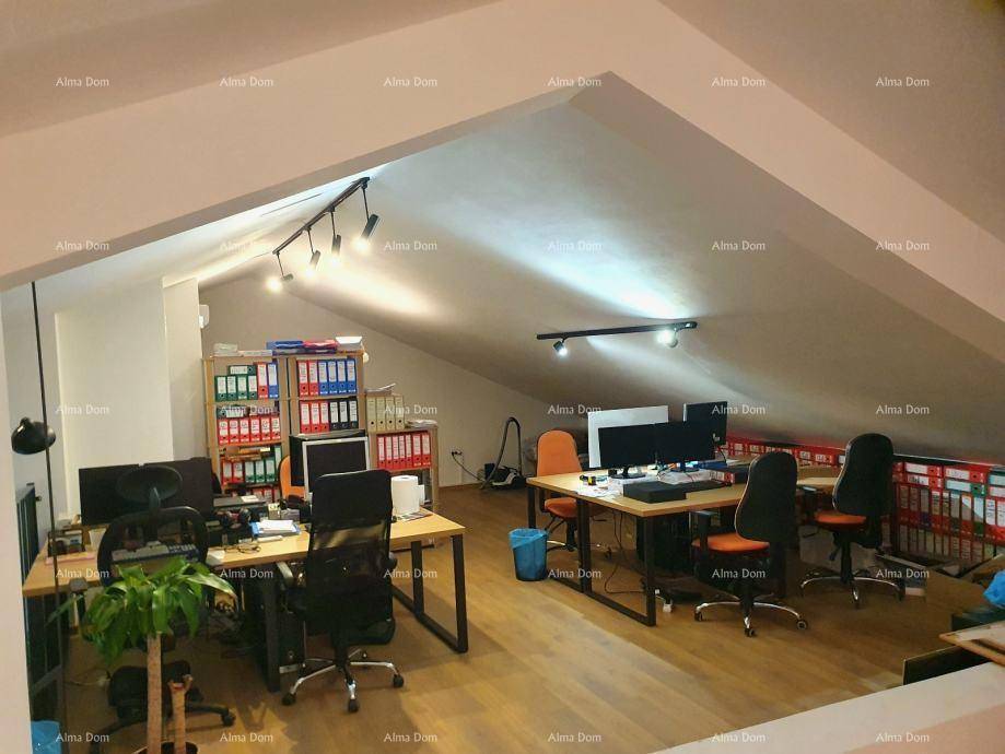 Großzügiger Bürobereich im Dachgeschoss mit mehreren Arbeitsplätzen und Holzfußboden.