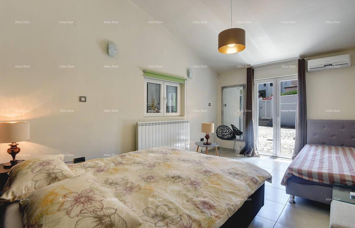 Helles Schlafzimmer mit Doppelbett, Einzelbett und Zugang zum Außenbereich.
