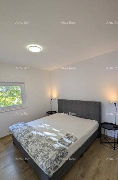 Helles Schlafzimmer mit Doppelbett, Nachttischen und Fenster mit Blick ins Grüne.