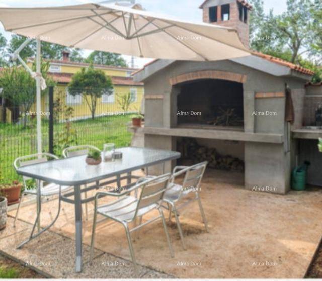 Gemütlicher Essbereich im Freien mit großem Grill und Sonnenschirm, ideal für gesellige Abende.