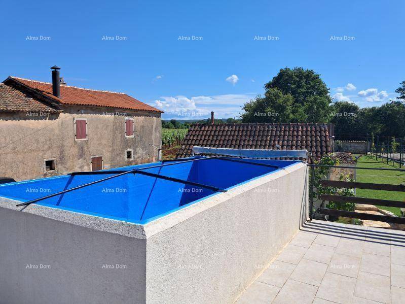 Erhöhter Poolbereich mit gepflasterter Fläche und weitem Blick über die Landschaft und Dächer.
