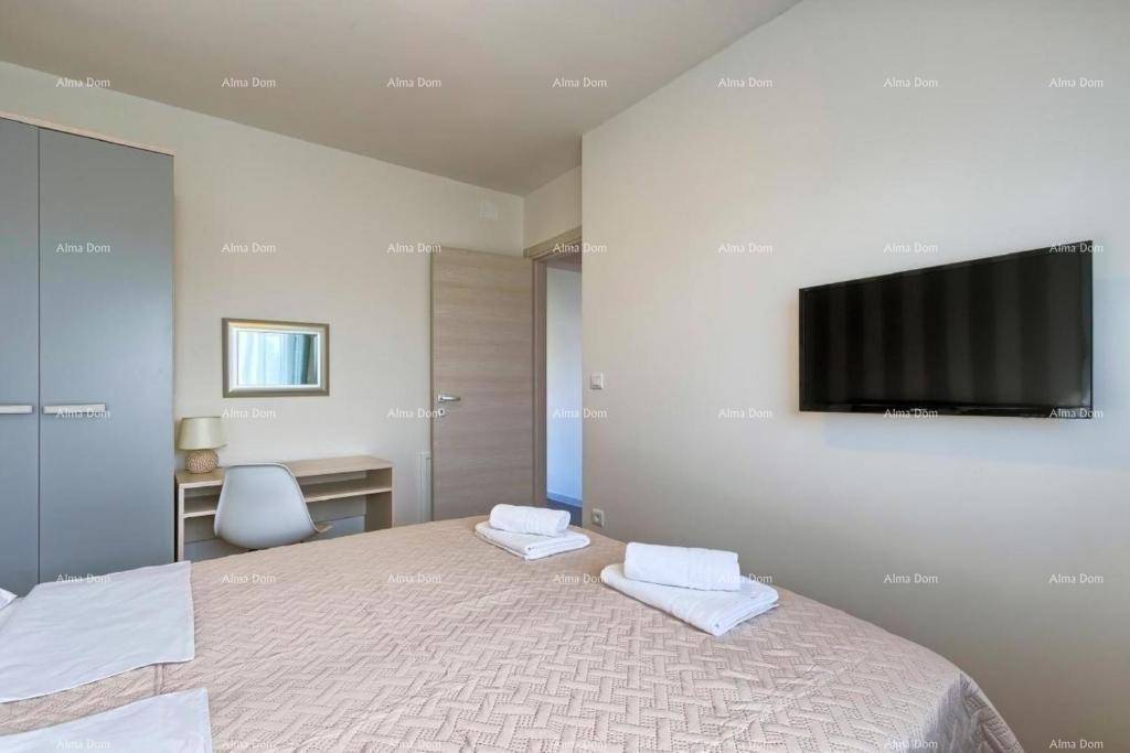 Schlafzimmer mit Doppelbett, Wandfernseher und hellem Interieur.