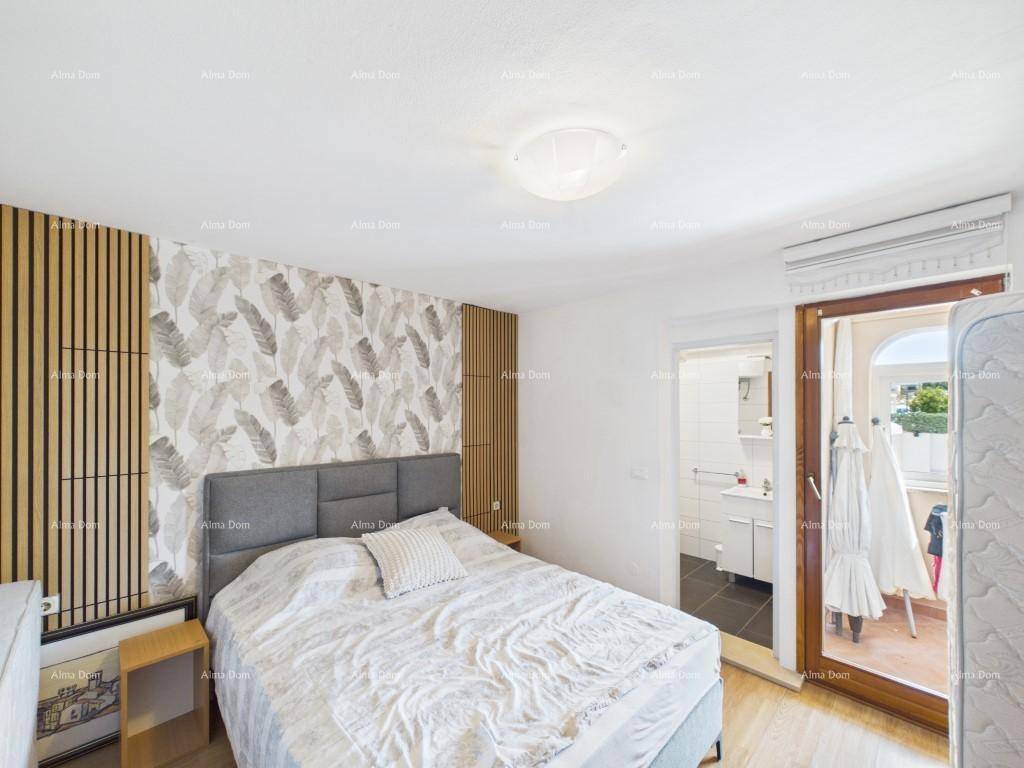 Schlafzimmer mit Doppelbett, floraler Tapete und direktem Zugang zu einem eigenen Badezimmer.