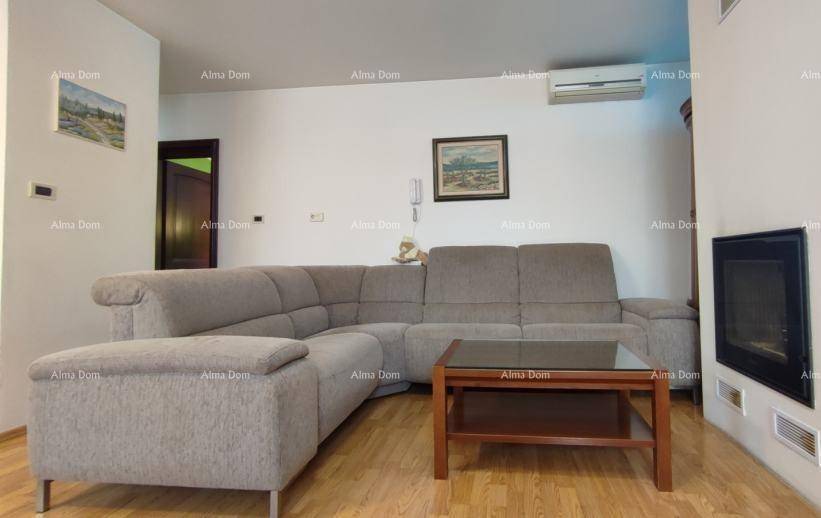 Helles Wohnzimmer mit Ecksofa, Couchtisch, Kamin und Klimaanlage.