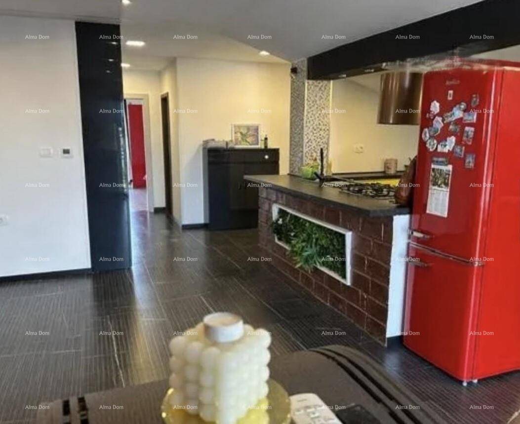 Offener Wohnbereich mit rotem Kühlschrank, Ziegeltheke und Blick auf den Flur.