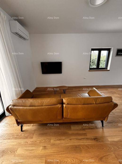 Gemütlicher Wohnbereich mit braunem Ledersofa, Holzboden und Wandfernseher.