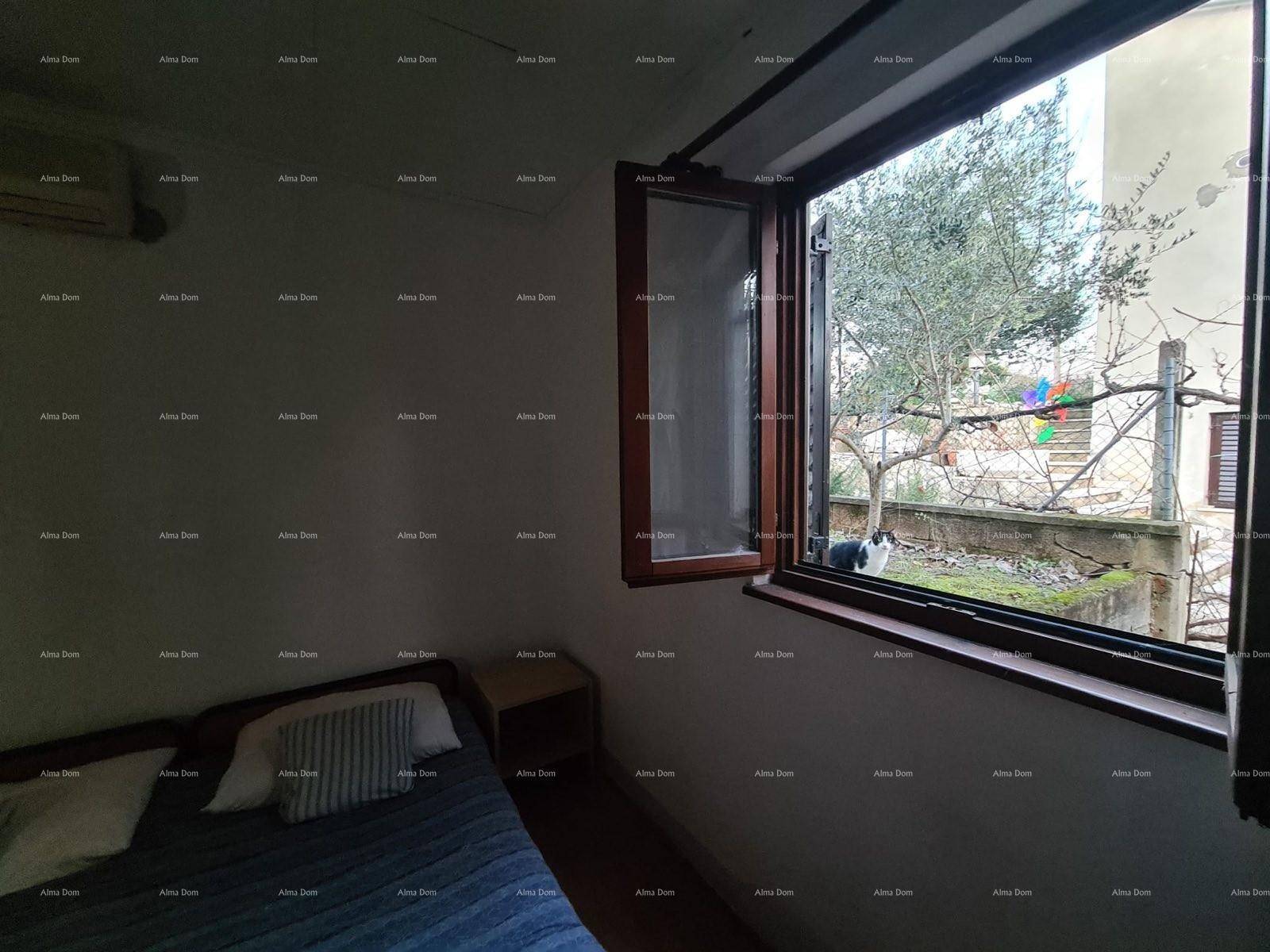 Schlafzimmer mit Bett und Fenster, das einen Blick auf den Garten bietet.
