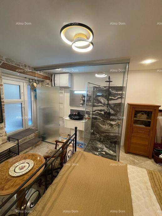 Modernes Schlafzimmer mit offenem Badezimmerbereich, begehbarer Glasdusche und stilvoller Deckenbeleuchtung.