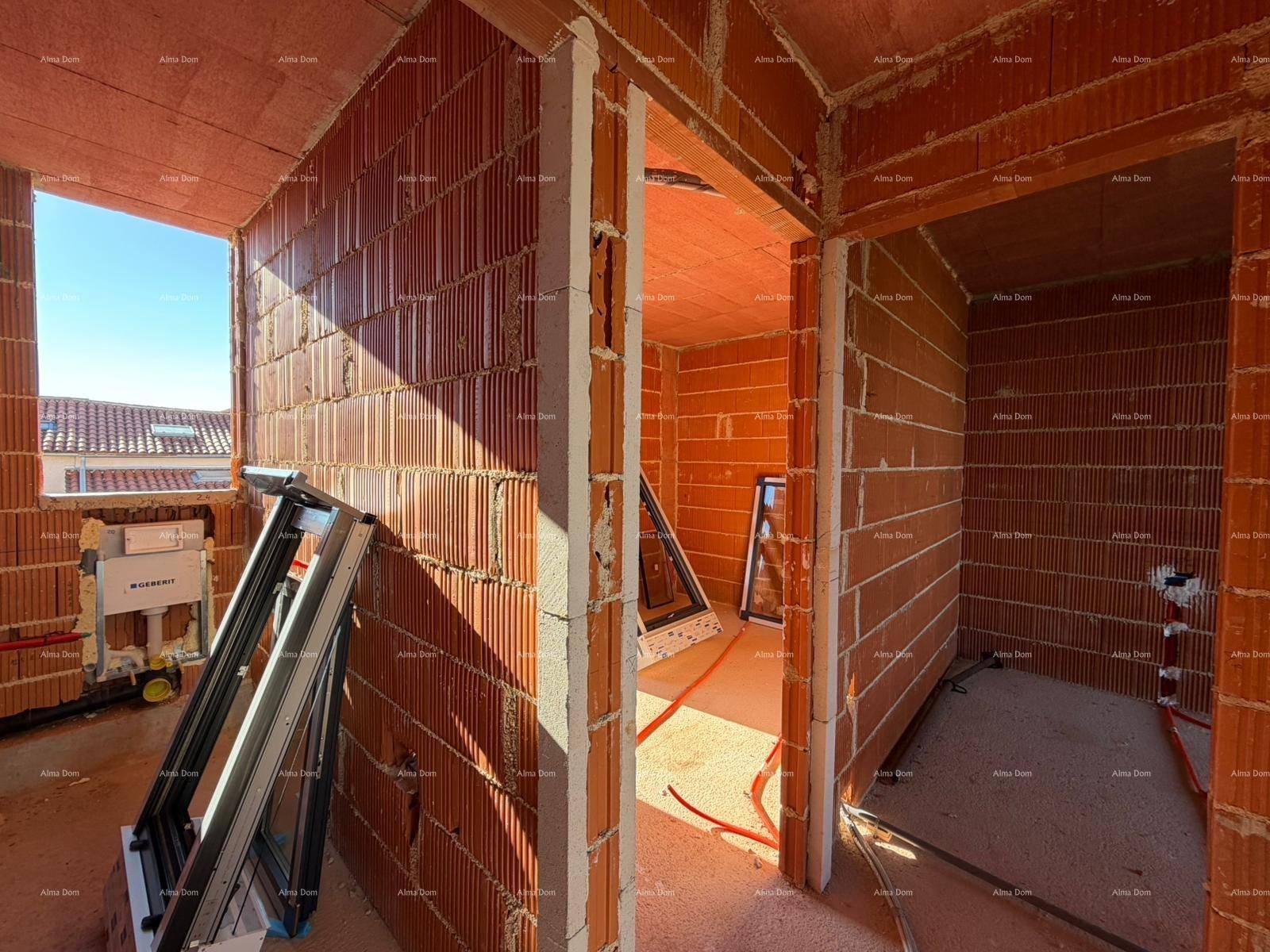 Innenraum im Rohbau mit Fensteröffnungen und Baumaterialien auf dem Boden.