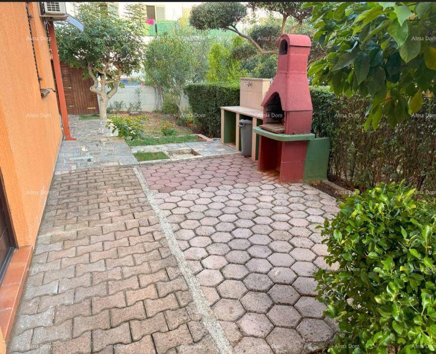 Außenbereich mit gepflasterter Fläche und gemauertem Grillplatz für gesellige Stunden.