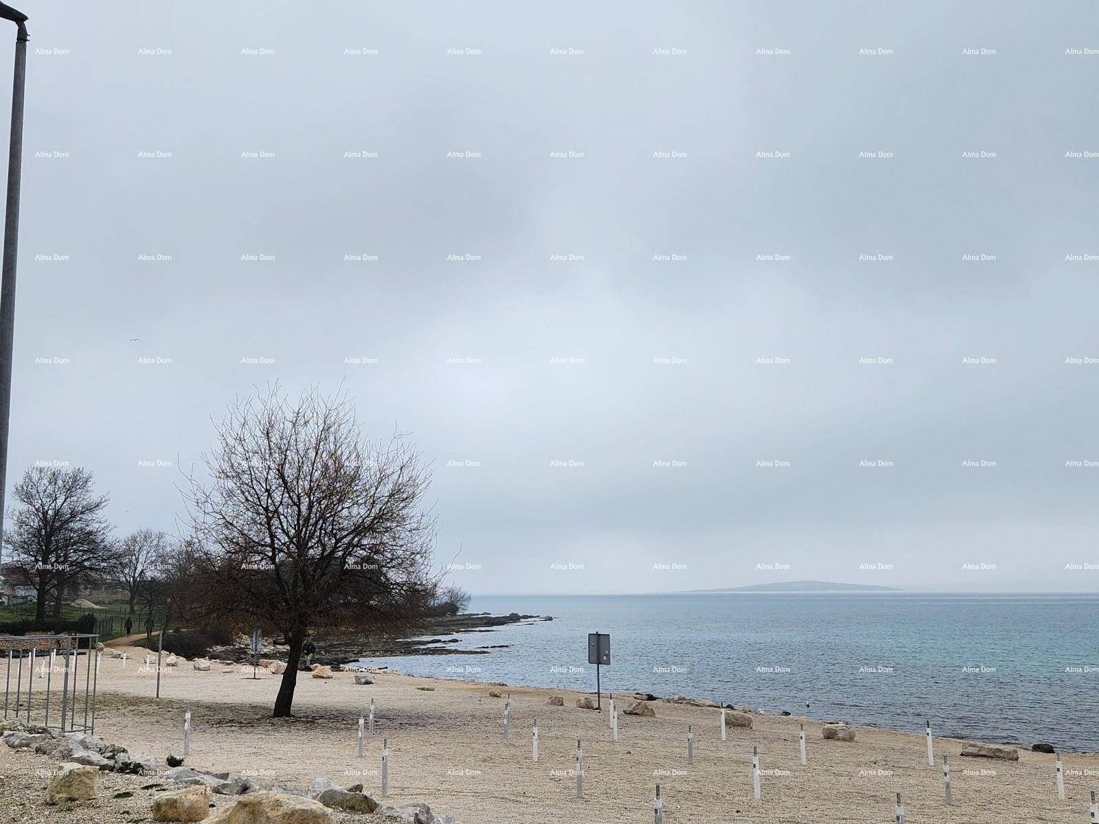 Malerischer Strand mit Meerblick unter einem bewölkten Himmel, ideal für Spaziergänge.