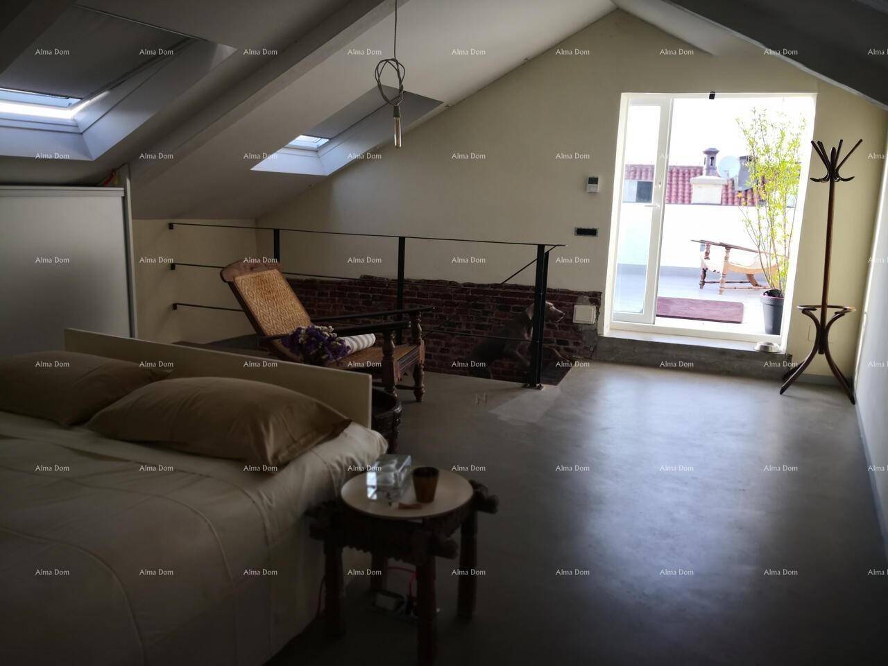Helles Schlafzimmer im Dachgeschoss mit Dachschrägen, Zugang zur Terrasse und freiliegenden Ziegelwänden.