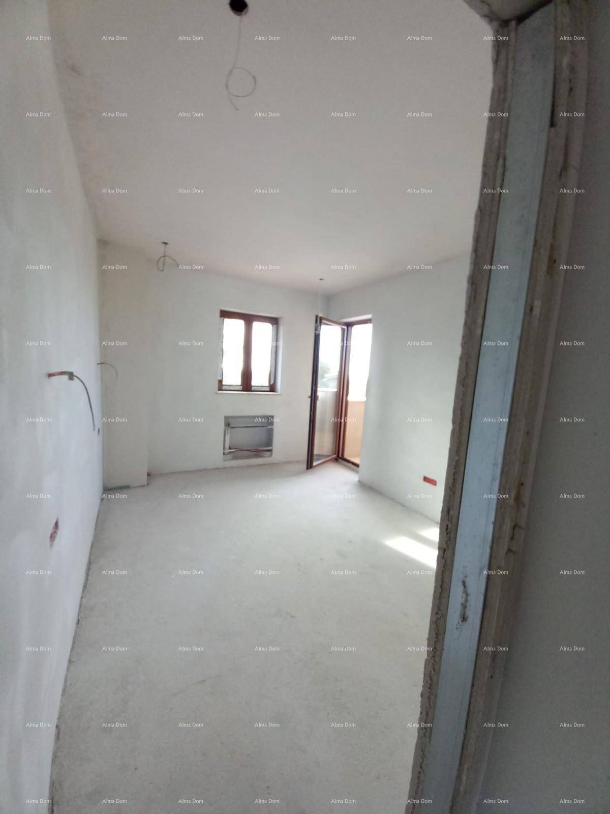 Heller Raum im Rohbau mit Fenster und Zugang zu einem Außenbereich.
