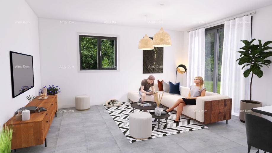 Gemütliches Wohnzimmer mit Sofa, Teppich und Blick ins Grüne durch das Fenster.