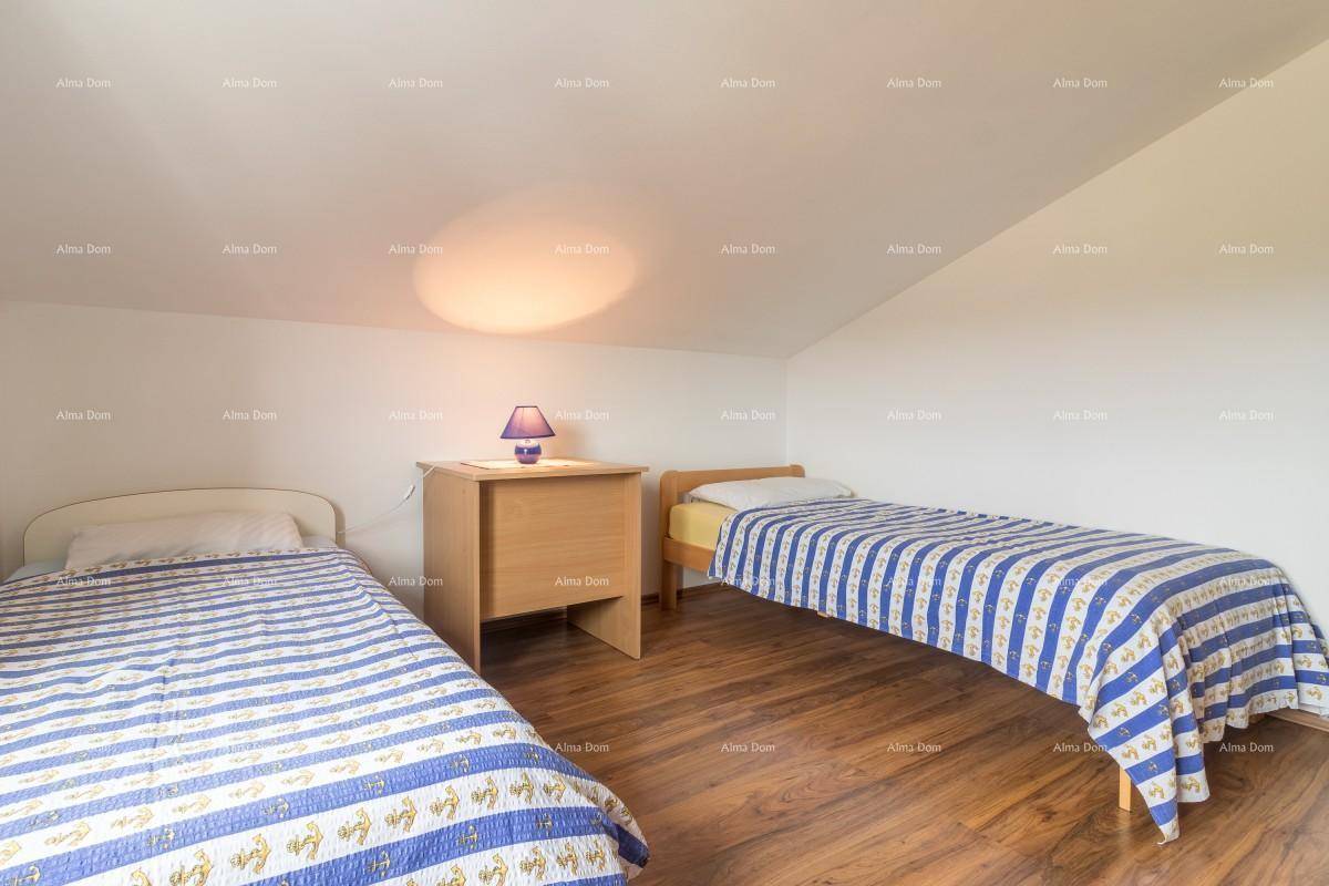 Gemütliches Schlafzimmer im Dachgeschoss mit zwei Einzelbetten und Holzboden unter einer Dachschräge.