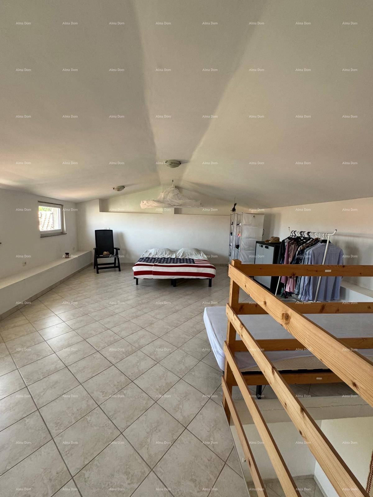 Geräumiges Schlafzimmer im Dachgeschoss mit mehreren Betten und Fliesenboden, hell und funktional.
