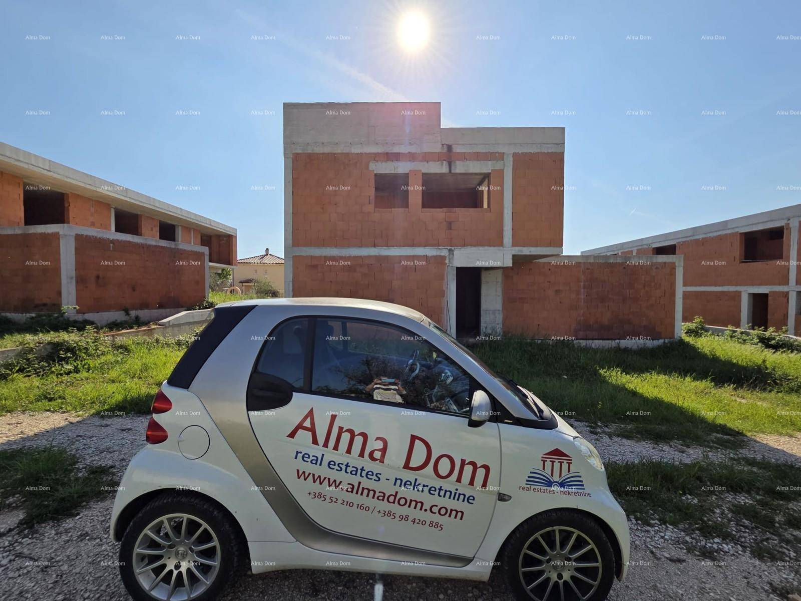 Ein Smart-Auto steht vor einem im Bau befindlichen Gebäude mit unverputzten Ziegelwänden unter strahlendem Sonnenschein.
