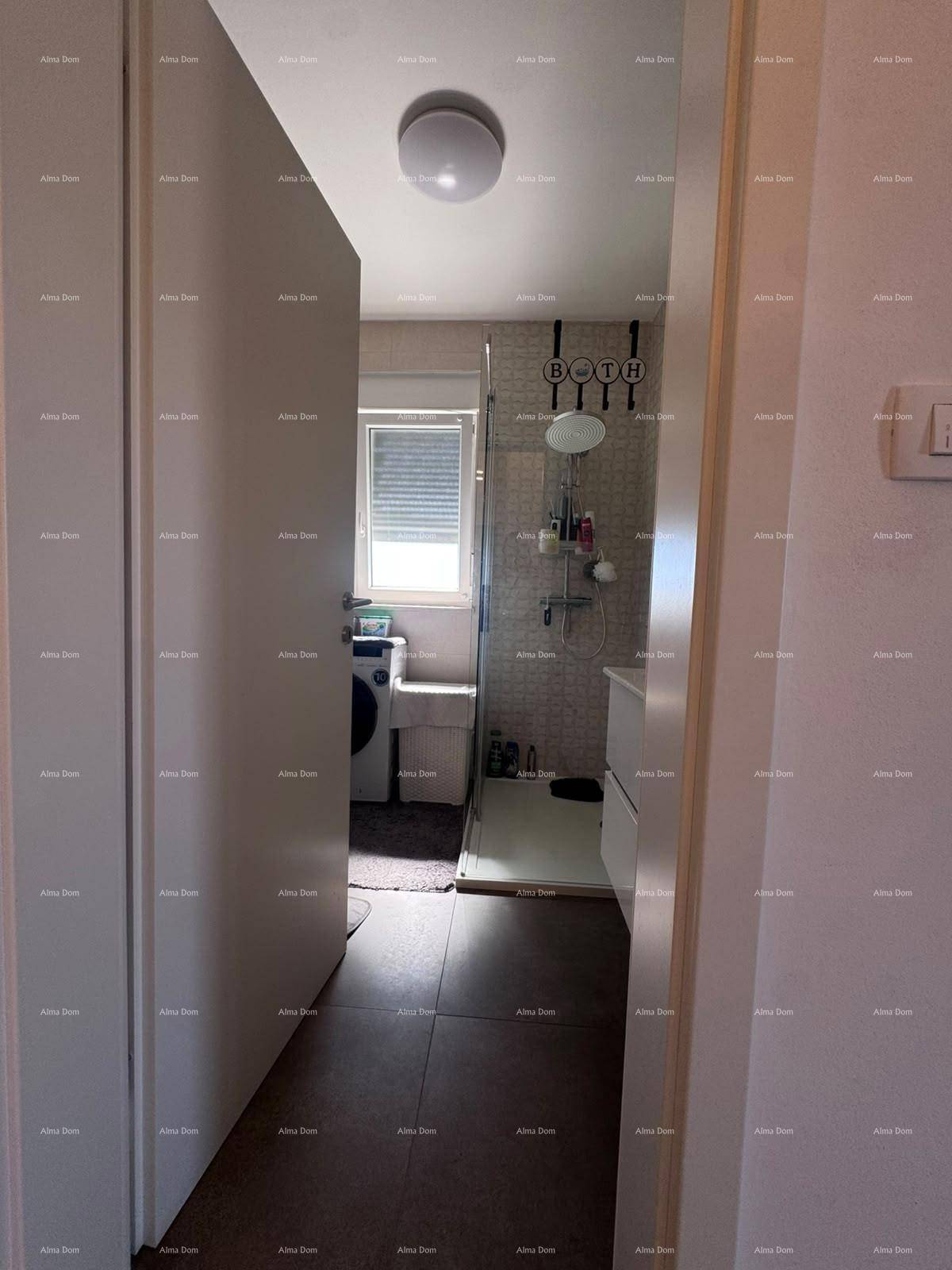 Blick in das moderne Badezimmer mit Dusche, Waschbecken und Waschmaschine.