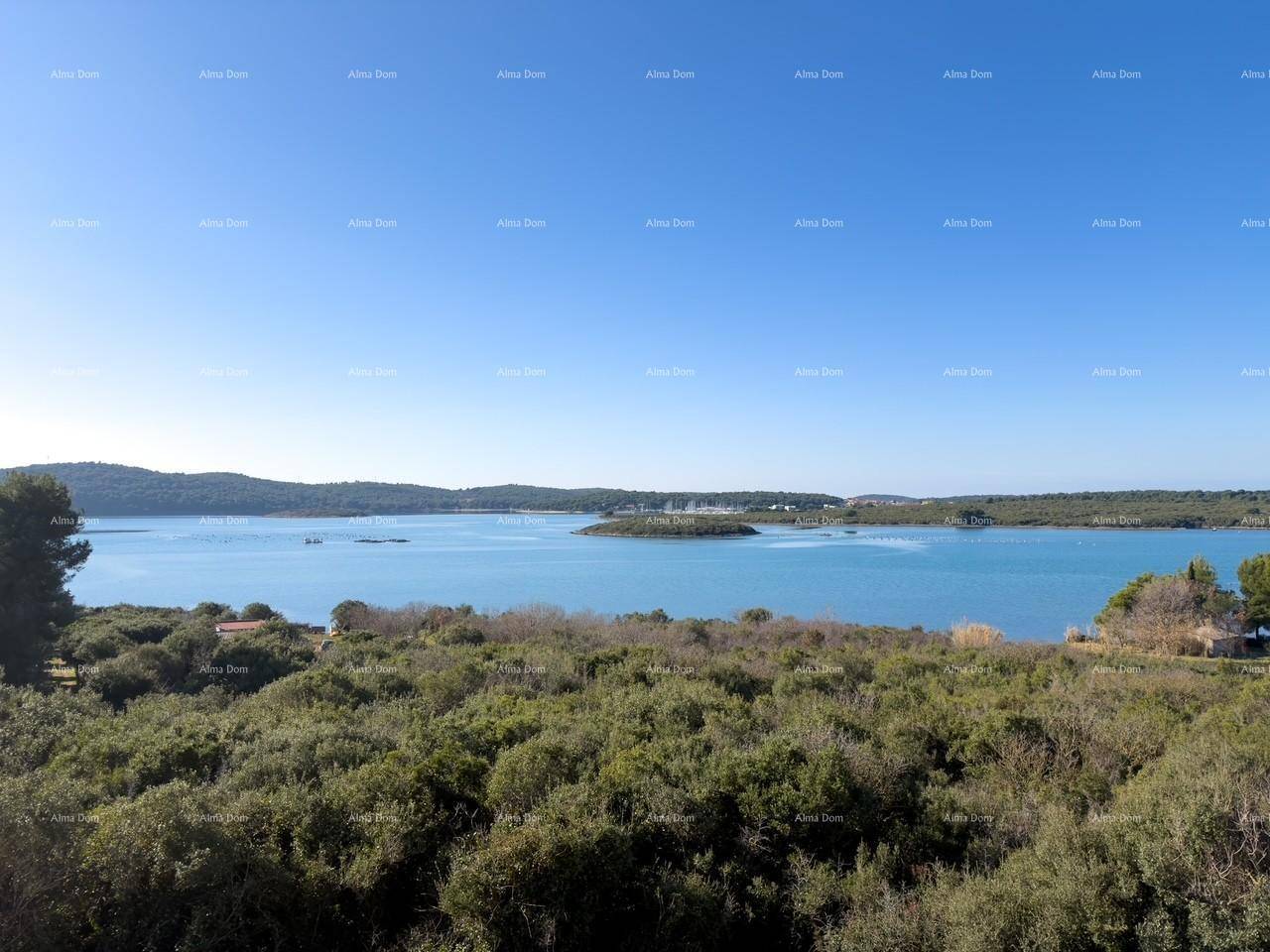 Weitläufiger Blick über die Bucht mit üppiger Vegetation und klarem blauem Wasser.