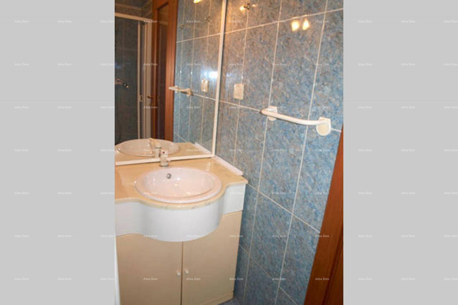 Waschbeckenbereich im Badezimmer mit Spiegel und blauen Fliesen.