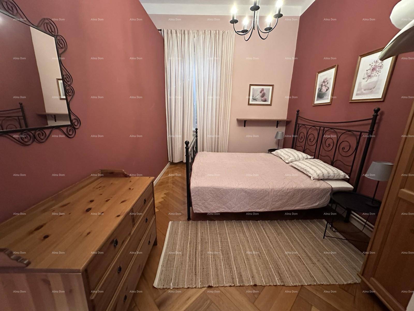 Schlafzimmer mit Doppelbett, schmiedeeisernem Rahmen, Fischgrätparkett und roten Wänden.
