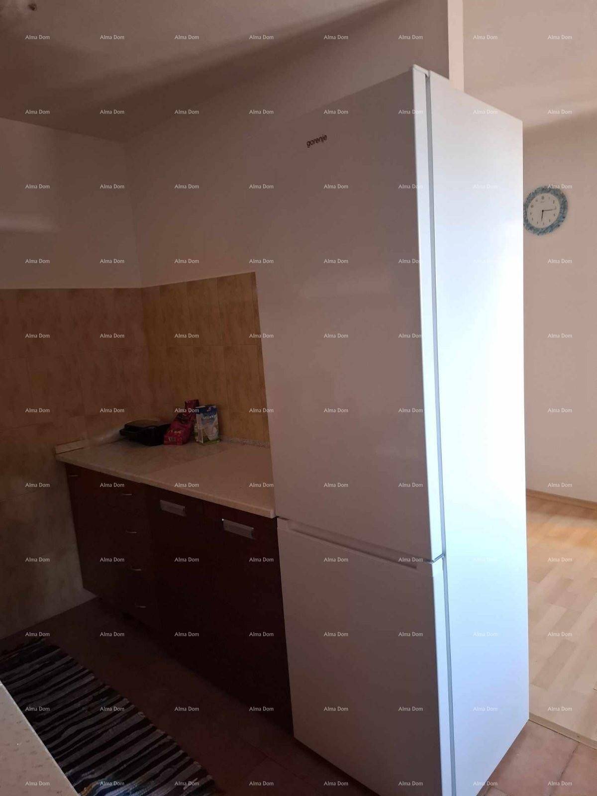 Großer Kühlschrank in einer Küche mit Holzschränken und hellem Fliesenboden.