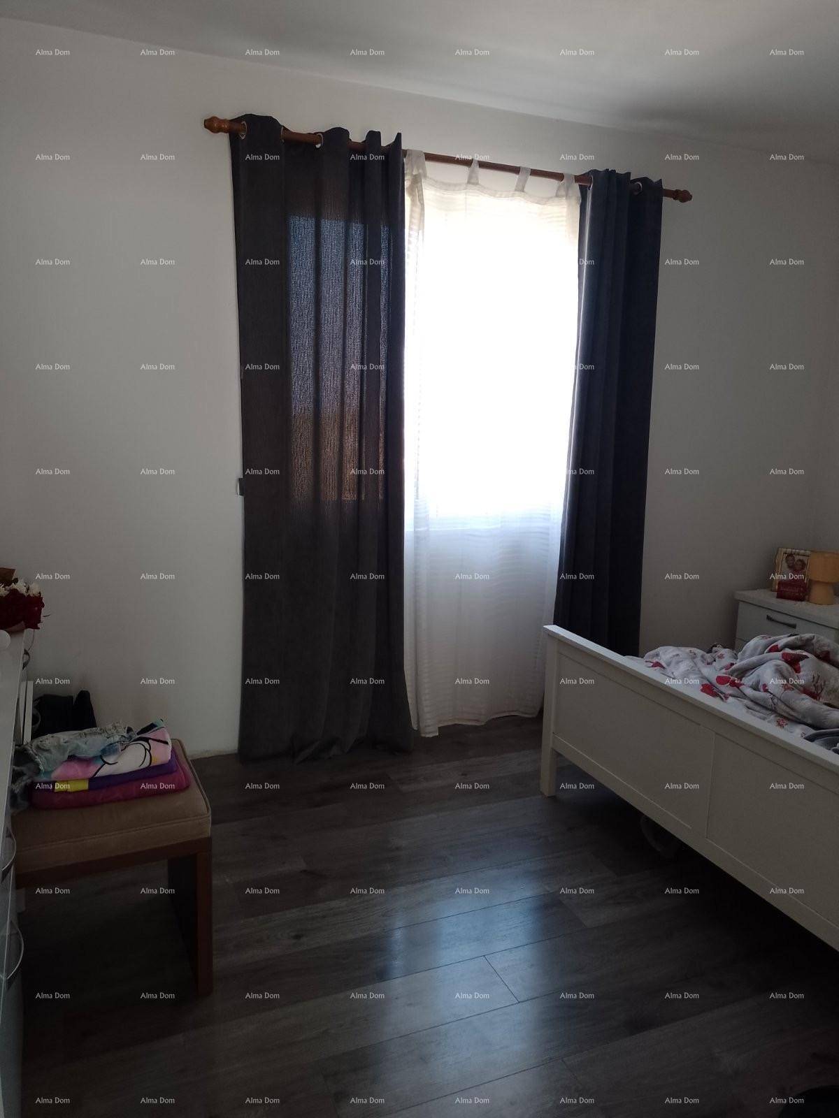 Schlafzimmer mit Laminatboden, Einzelbett und dunklen Vorhängen am Fenster.