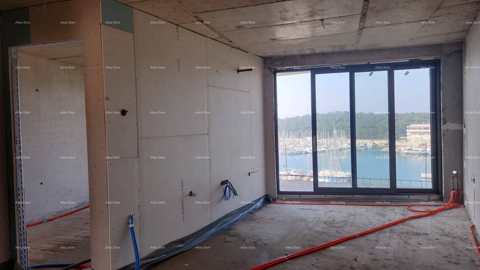 Rohbau eines Zimmers mit Trockenbauwänden, sichtbaren Installationen und Blick auf den Yachthafen.