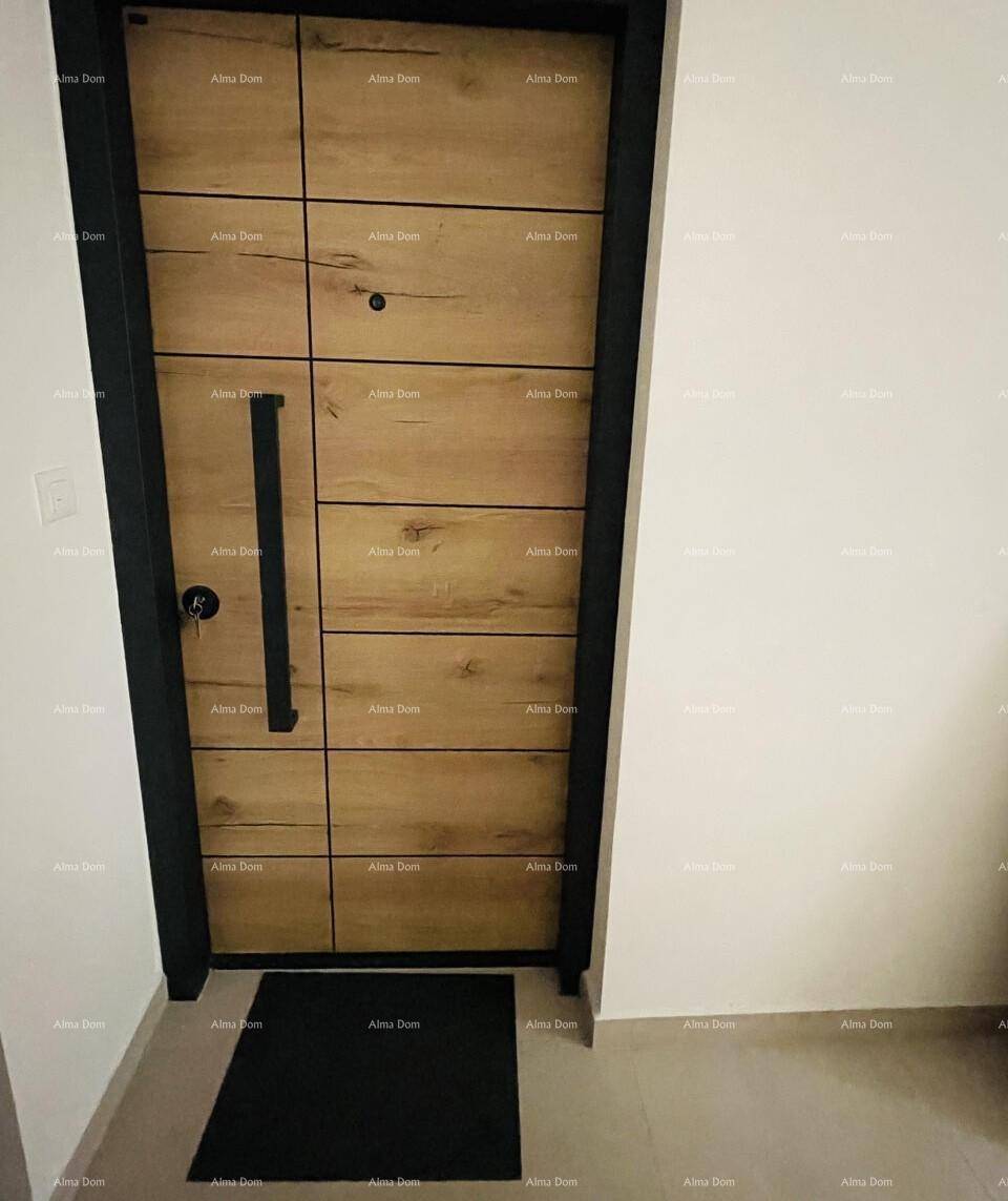 Moderne Eingangstür mit Holzpaneelen und schwarzem Rahmen in einem hellen Flur.